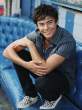Zac_Efron_blue_seat_crouched_down_looking_away_smile_181007.jpg